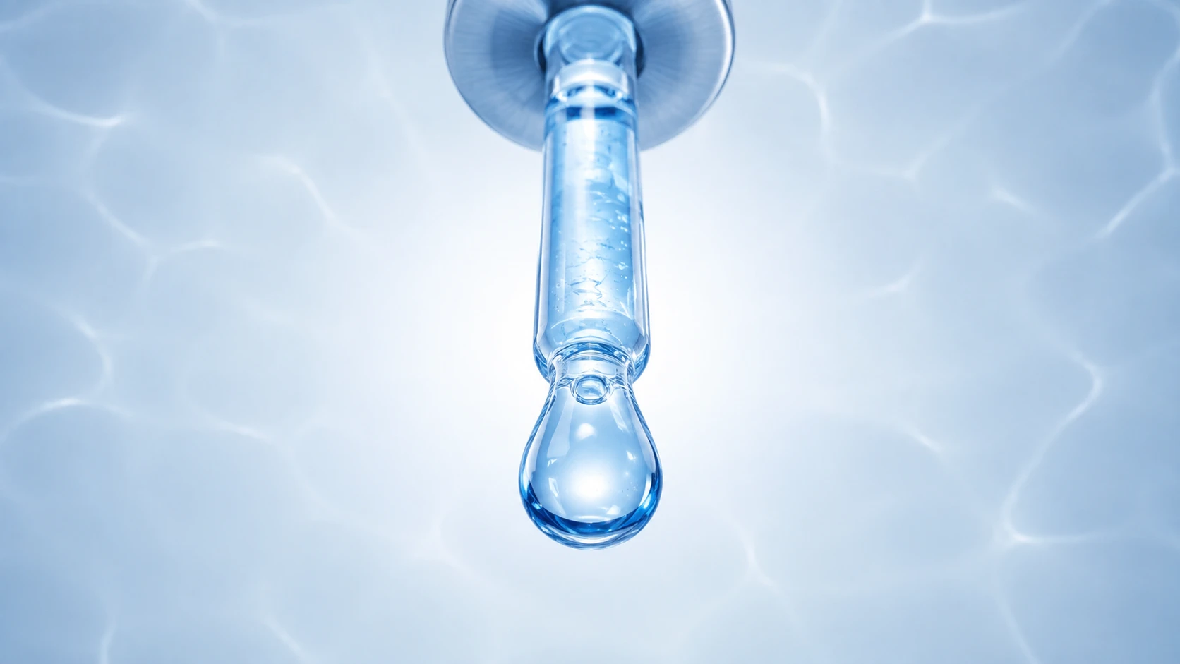 An underside view looking directly up at a pipette and suspended blue drop.